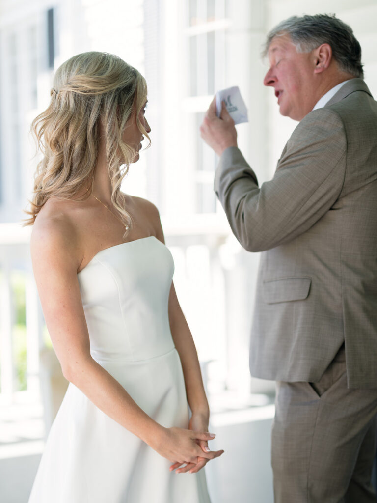 dad wiping away tears during first look with blonde bride in white dress