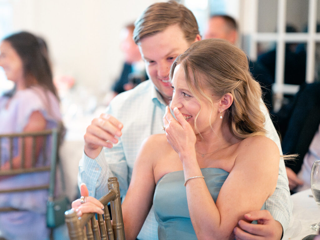bridesmaid laughing covering her face with her hand looking on as toasts were made during reception at payne corley house