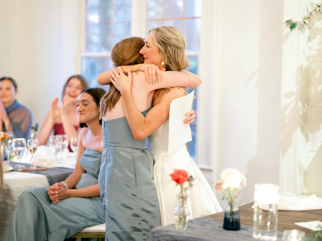 bride and sister embrace after speech