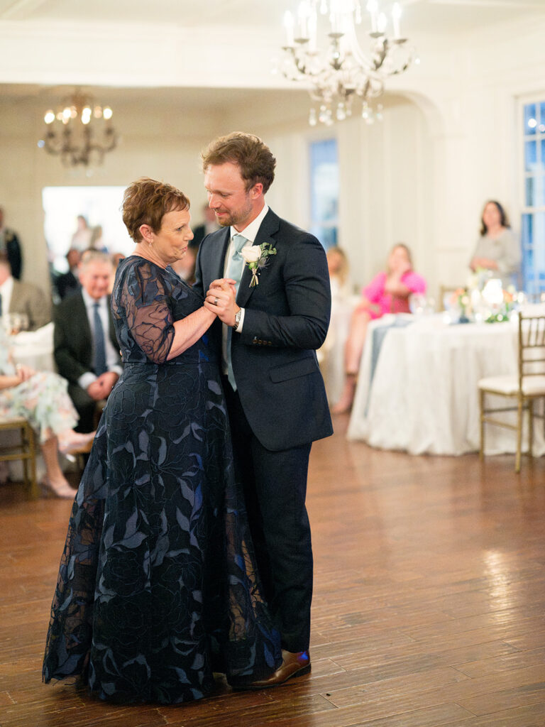 mother of the groom and groom dance during the reception at payne corley house