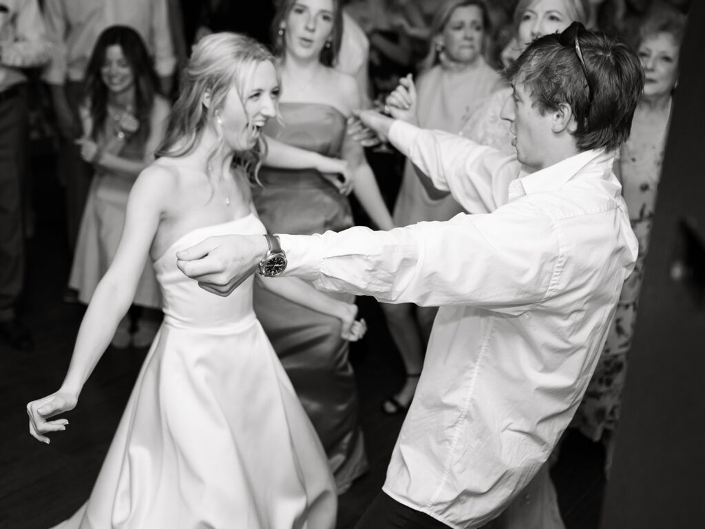 bride and brother of the bride dancing in black and white