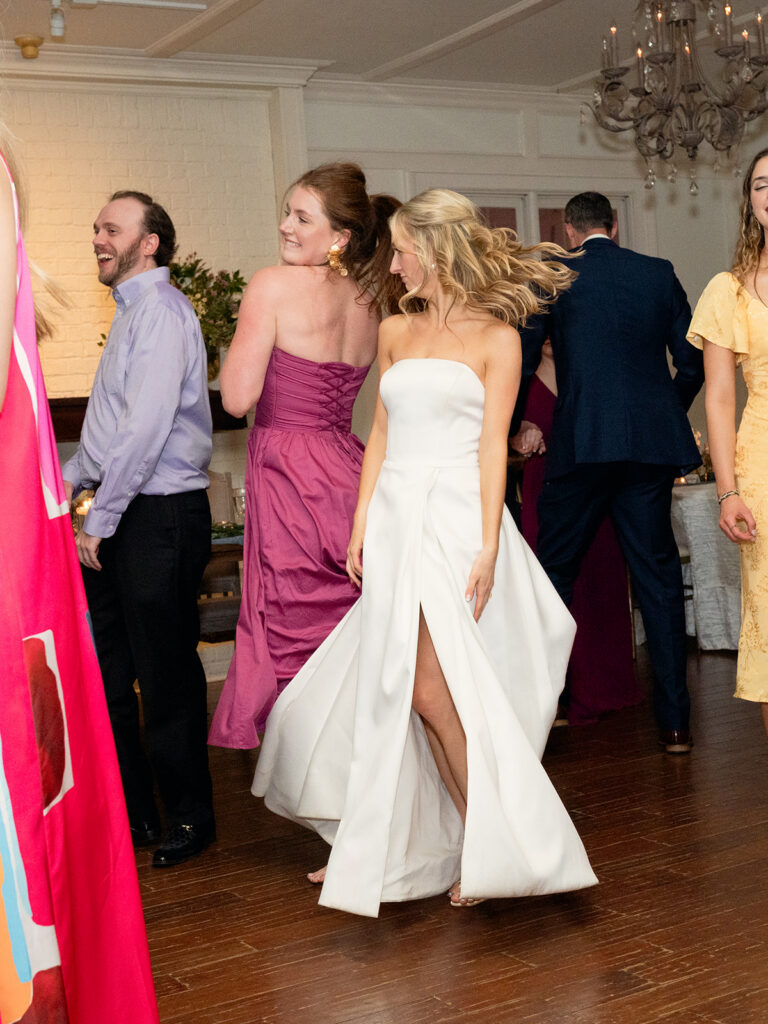 bride dancing with girl in pink dress hair wild in white