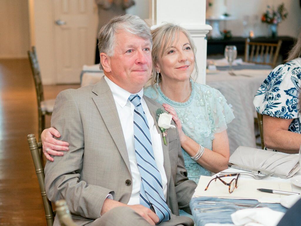 dad and mom looking on with teary faces during reception moments